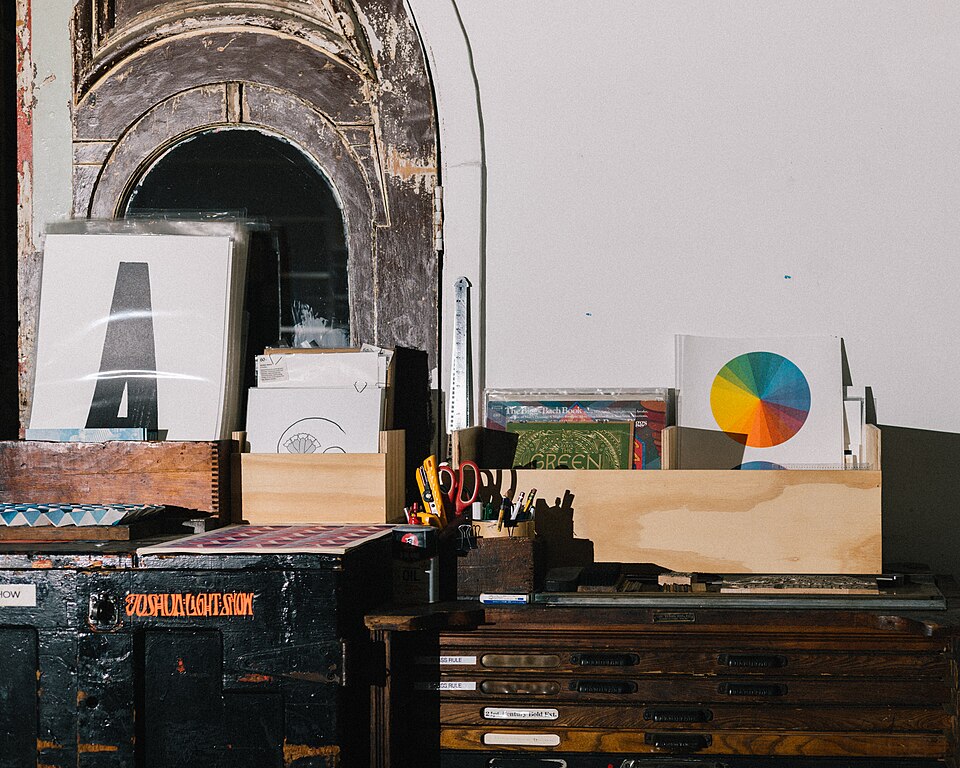 A photo of a counter in The Arm, a letterpress shop in Brooklyn, New York. Prints are placed in wooden boxes.